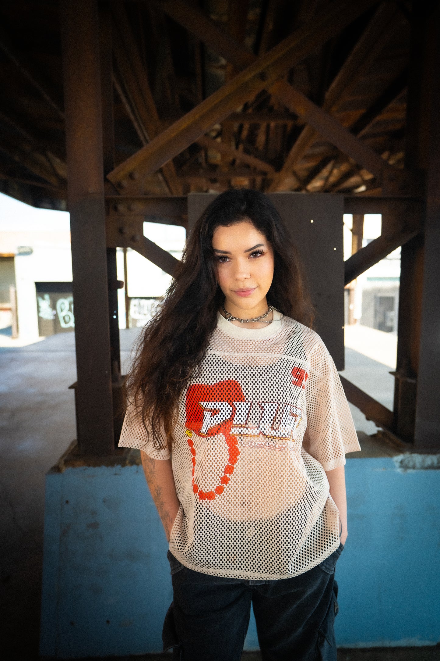 Model wearing Raver Vibes Only Legacy Jersey – Apricot beige PLUR inspired rave jersey with red 93 print, white PLUR Vibes Only logo, and kandi chain graphic. Unisex EDM festival streetwear outfit