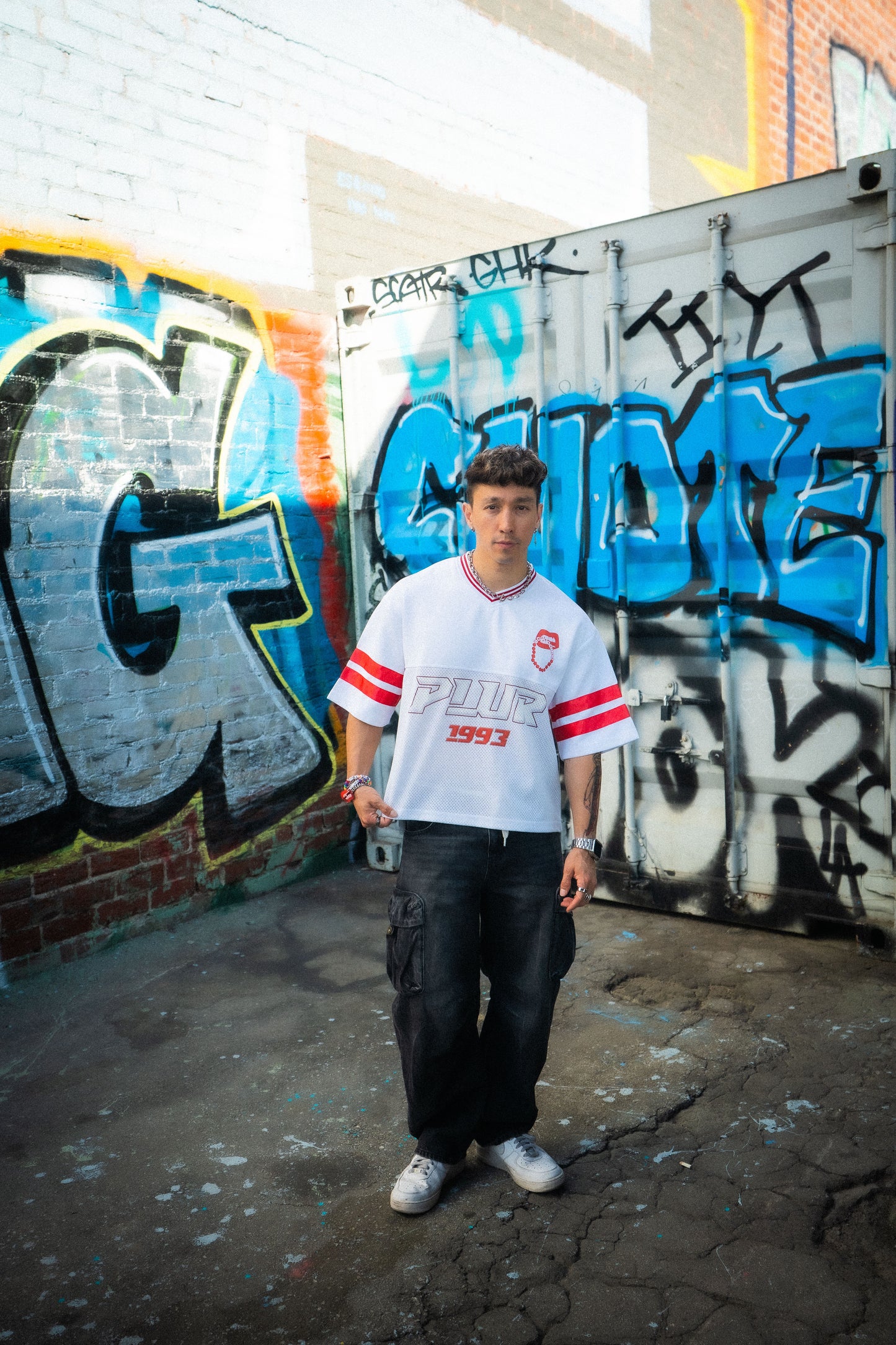 Lifestyle shot of white and red Raver Manifesto Legacy Jersey styled for music festivals, rave streetwear apparel