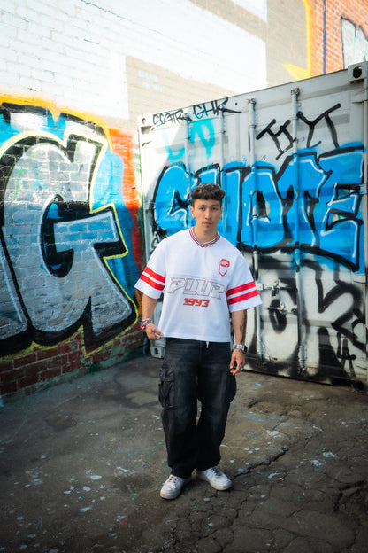 Lifestyle shot of white and red Raver Manifesto Legacy Jersey styled for music festivals, rave streetwear apparel